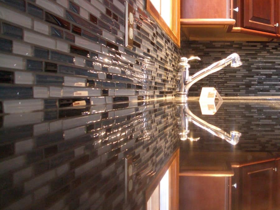 Tiled kitchen backsplash running between the counter and wall cabinets